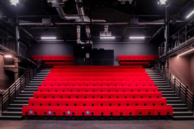 Salle de théâtre équipée de fauteuils rouges en gradins Salle de théâtre équipée de fauteuils rouges en gradins