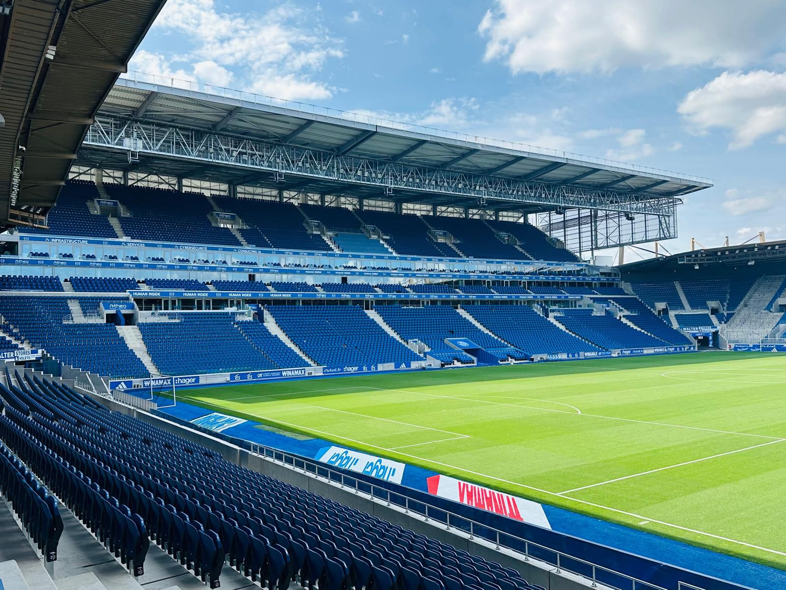 Corner of the stadium after installation, rows of blue seats in the foreground and the opposite stand behind